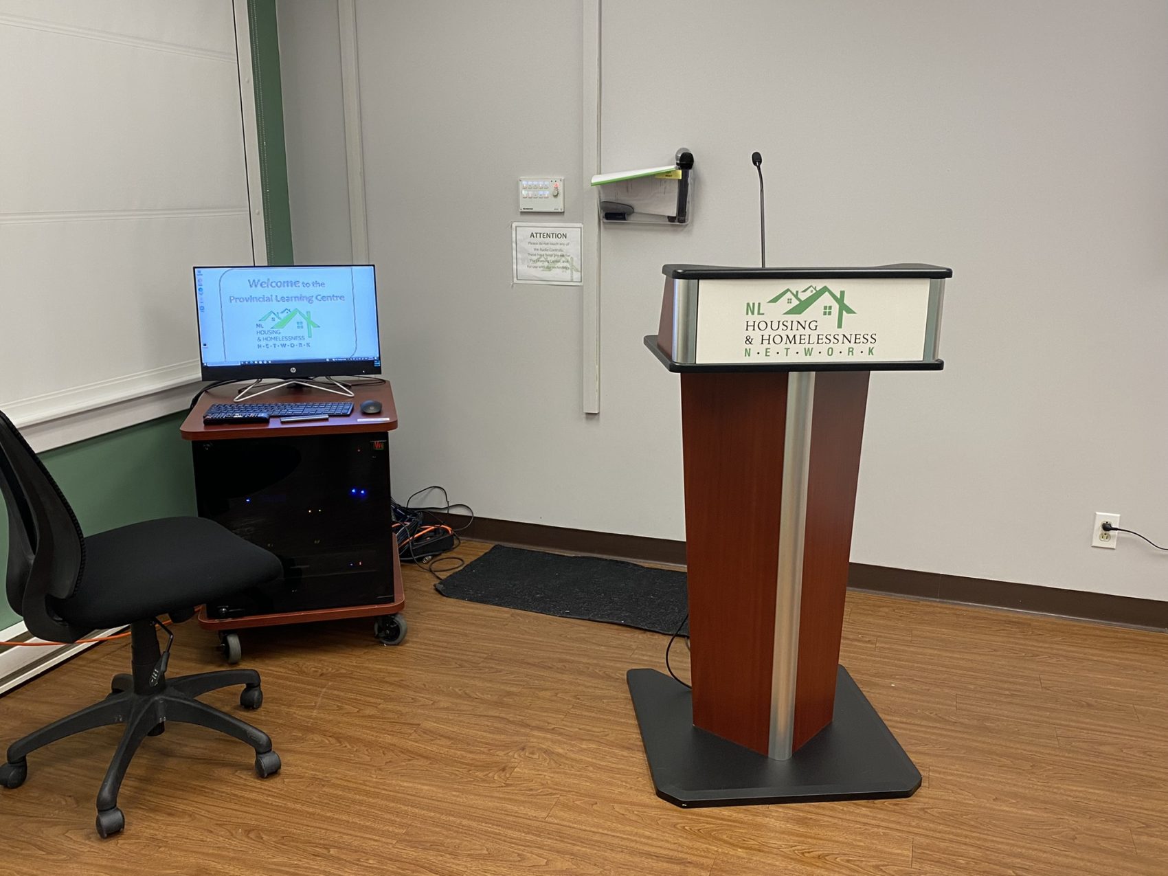 A podium with microphone next to a computer station.